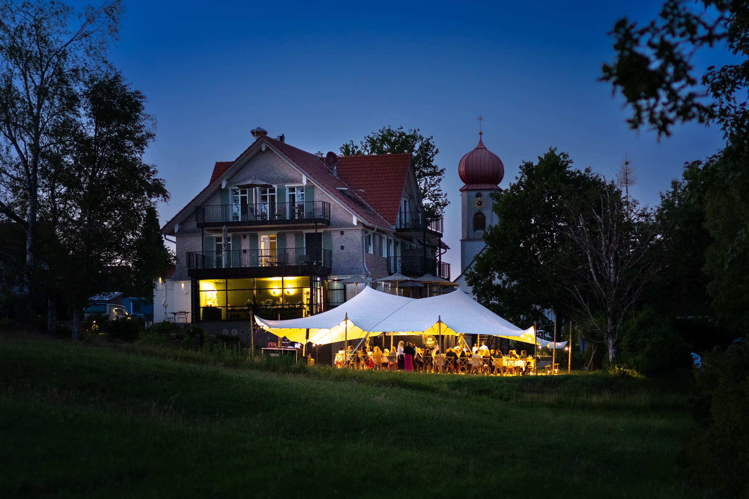 Anwesen und Dorfkirche in der Abenddämmerung