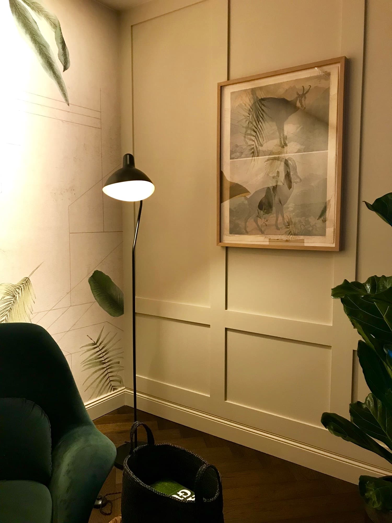 Loungeecke mit Stehlampe und gerahmtem Wandbild